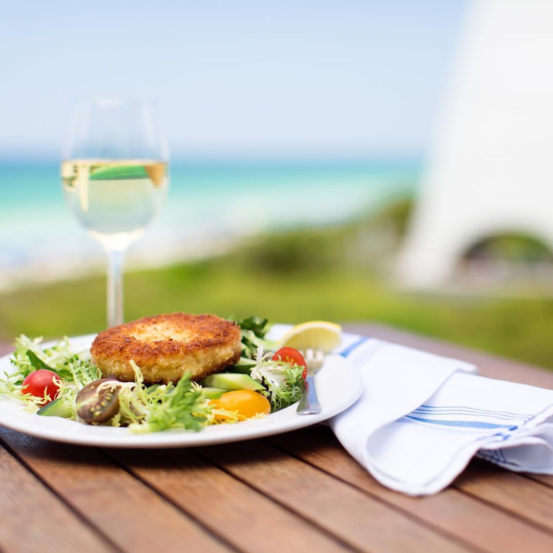 Crab cake salad with fresh greens and white wine overlooking the ocean.