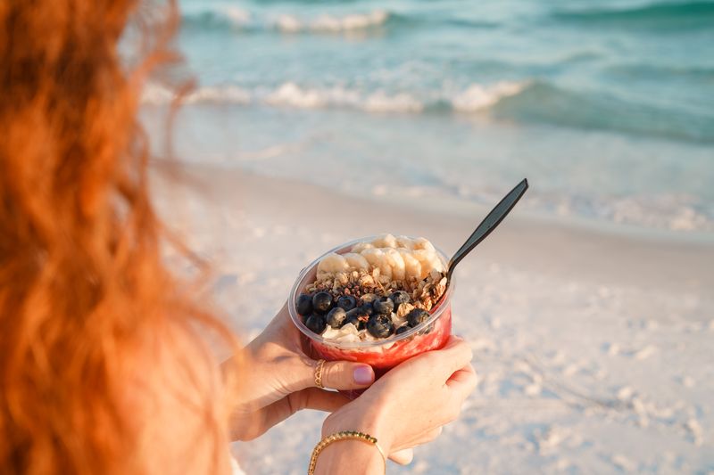 A woman enjoying a dessert from The Green Stream on Seaside Beach